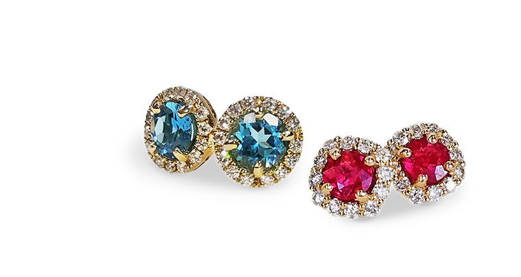 one pair each of diamond halo pierced stud earrings with prong set ruby and blue topaz gemstones in the center of design